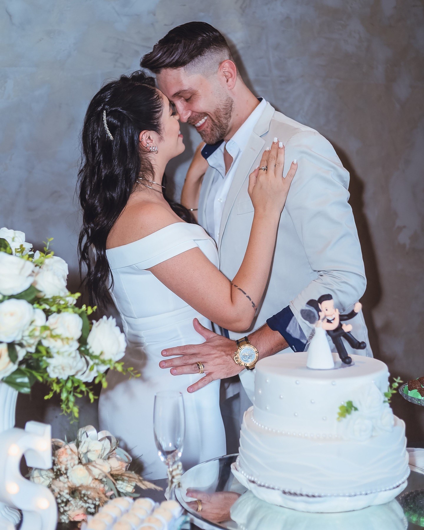 Fotografia de casamento — casal abraçado junto ao bolo
